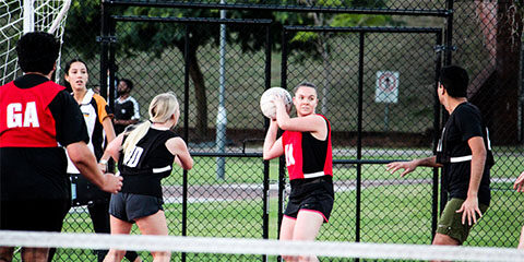 Students playing netball on outdoor courts